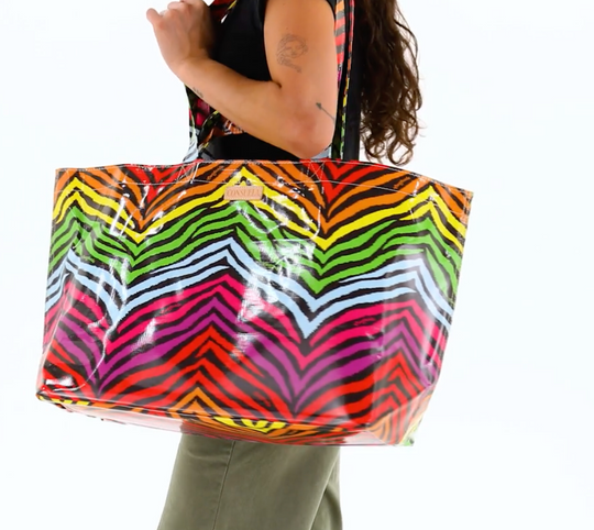 Colorful zebra print Consuela jumbo bag with black handles worn over shoulder by woman