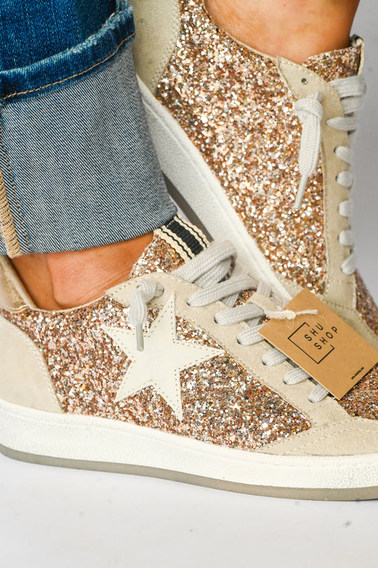 Paz Champagne Shu Shop Sneakers with gold glitter and white star detail worn with cuffed jeans