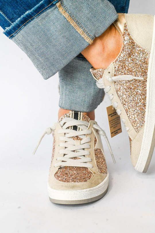 Paz Champagne Shu Shop Sneakers with glitter detail and white laces worn with rolled-up blue jeans