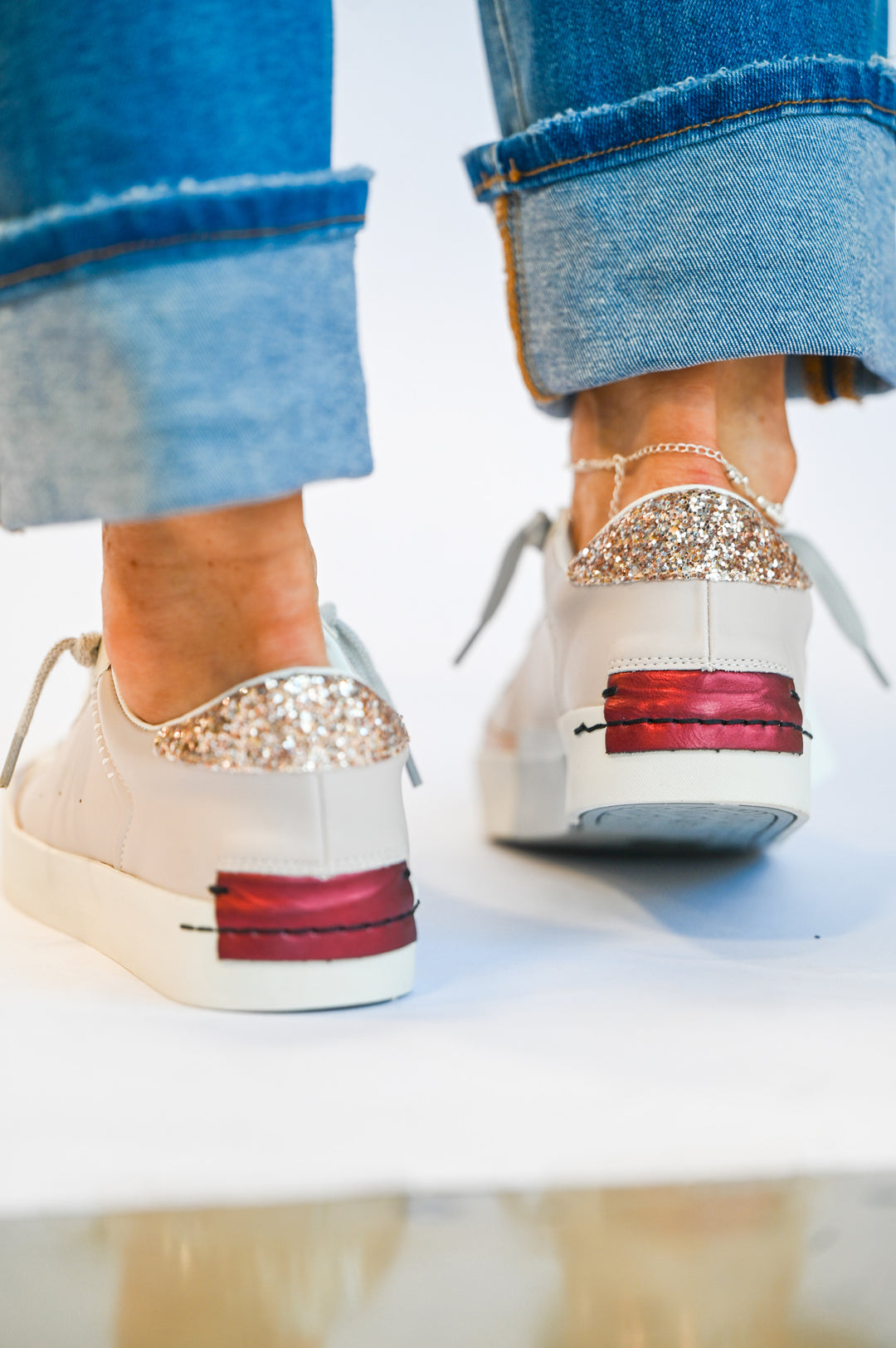 Back view of Ruby Mushroom Shu Shop sneakers in white with glitter heel detail and red sole accents