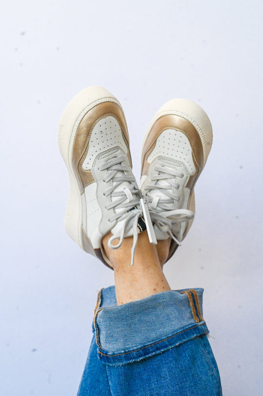 Sheena Shu Shop sneaker in white and beige worn with rolled-up blue jeans