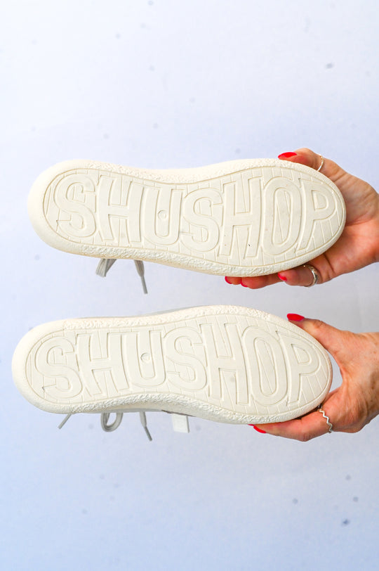 Bottom view of Sheena Shu Shop sneaker showing branded sole with ShuShop logo in white
