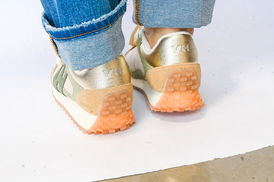 Back view of gold and beige Vintage Havana sneakers worn with rolled-up blue jeans