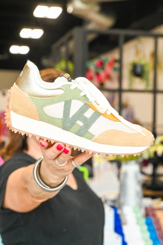 Vintage Havana sneakers in beige green and white held by person indoors with blurred background