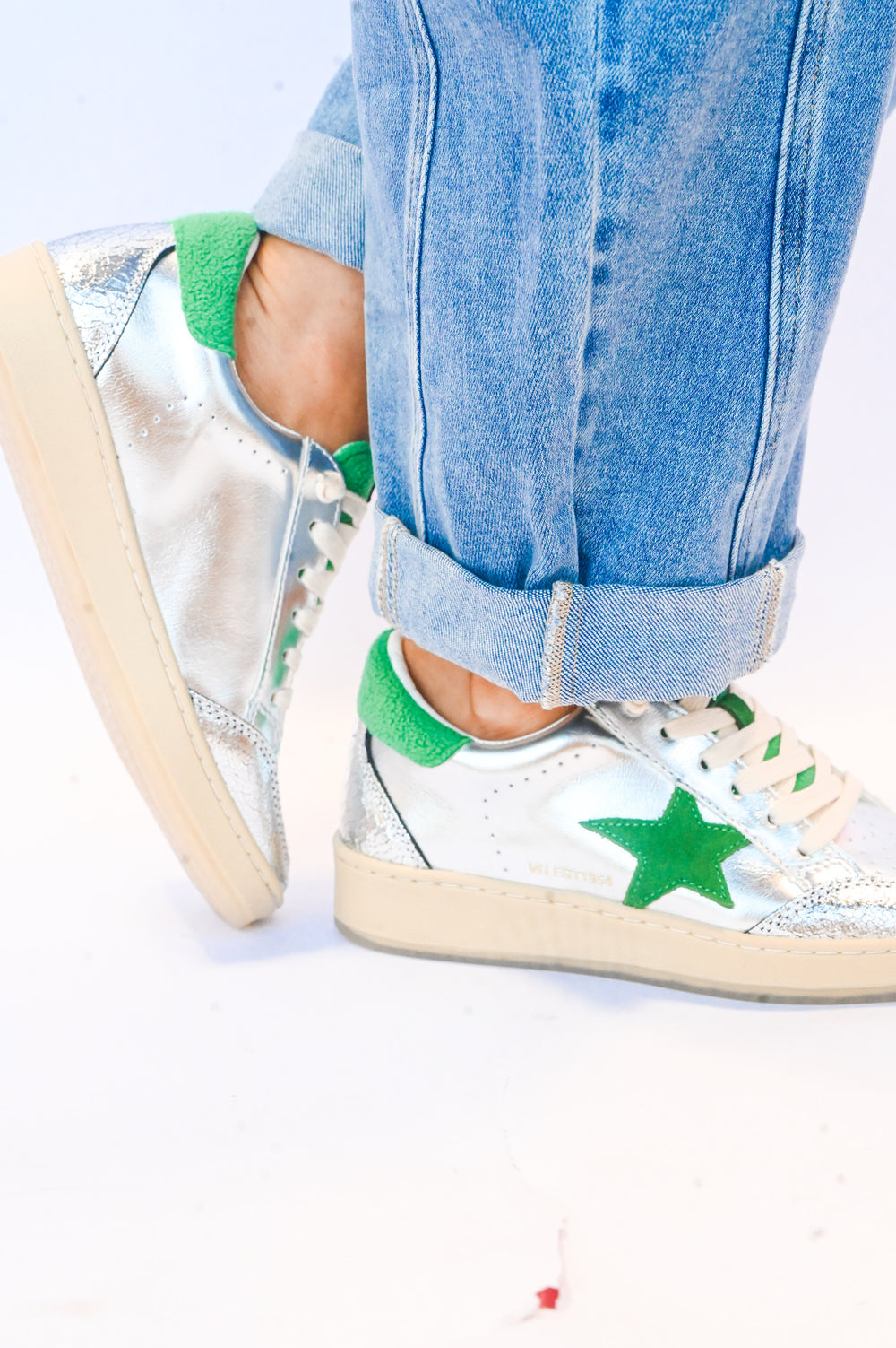 Silver and green Vintage Havana sneakers worn with rolled-up blue jeans for casual style