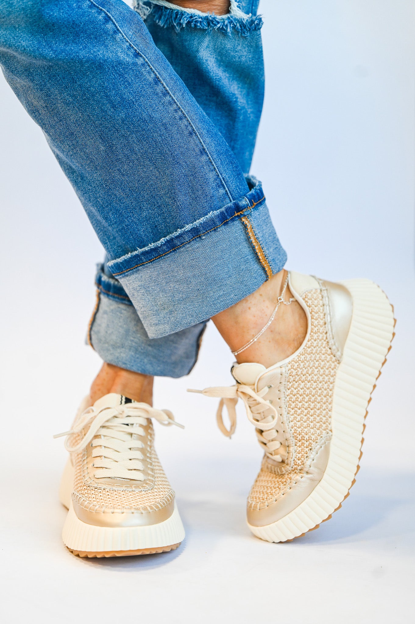 ShuShop gold sneaker fashion with woven texture and thick white soles paired with rolled-up blue jeans