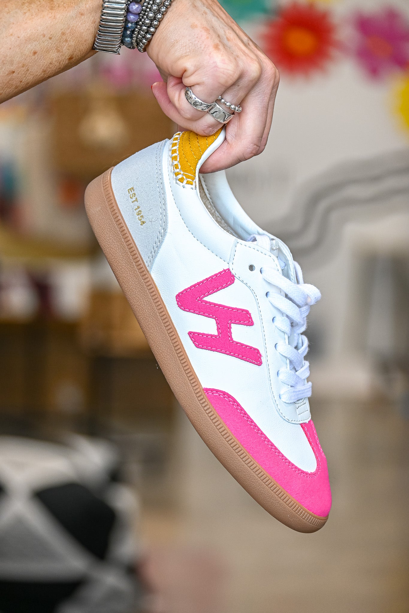 White and pink Vintage Havana sneakers for women with gum sole and yellow accent held by hand
